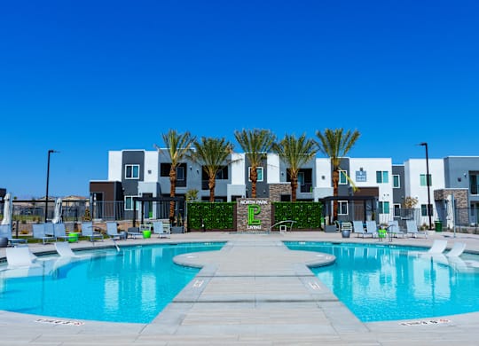 A swimming pool in front of a row of modern houses.