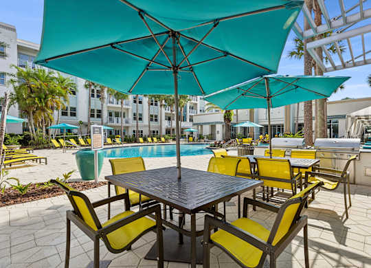 A table with chairs and umbrellas is set up outside.