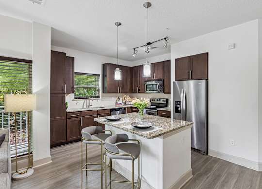 A modern kitchen with a center island and stainless steel appliances.