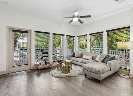 A living room with a grey couch, a coffee table, and a ceiling fan.
