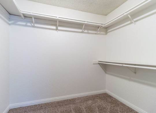 a walk in closet with a hanging rack on the wall