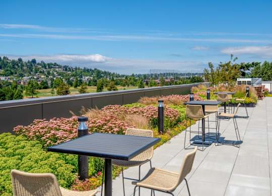 A patio with a table and chairs overlooking a city.