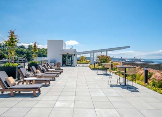 A patio with chairs and a building in the background.