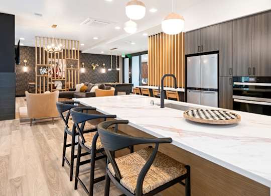 A modern kitchen with a long island and bar stools.