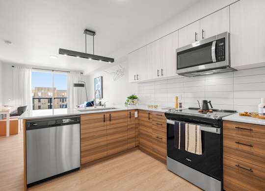 A modern kitchen with a stainless steel dishwasher and oven.