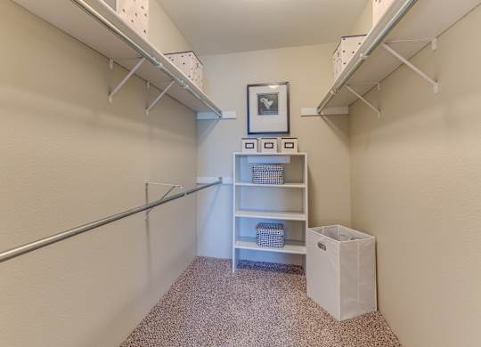 A small room with a shelf and a trash can.