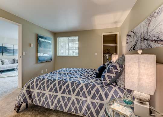A bedroom with a large bed and a painting on the wall.