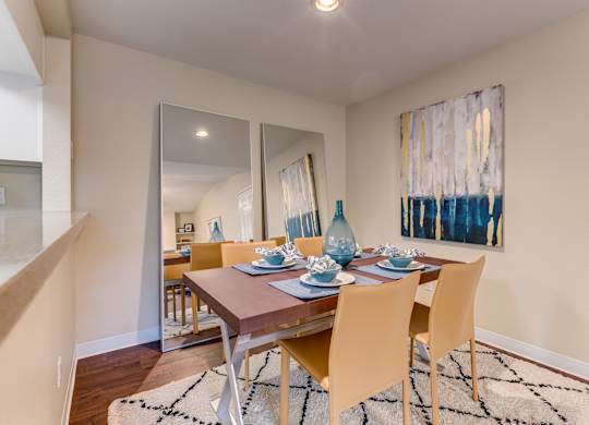 A dining room with a wooden table and chairs.
