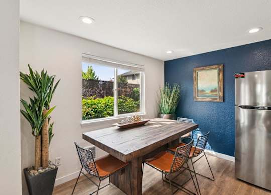 A dining room with a wooden table and chairs.