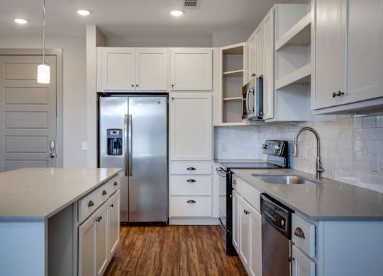 a kitchen with white cabinets and stainless steel appliances