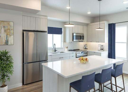 A modern kitchen with a large island and stainless steel appliances.