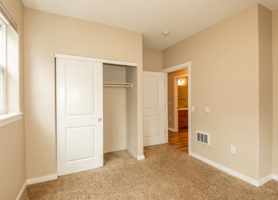 a bedroom with an open door to a closet and a hallway to a bathroom