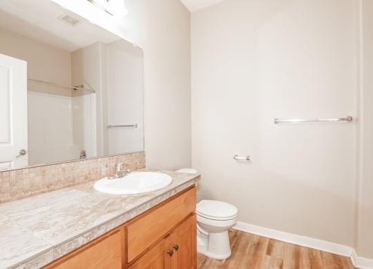 an empty bathroom with a sink toilet and mirror