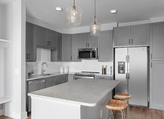 A modern kitchen with a large island and stainless steel appliances.