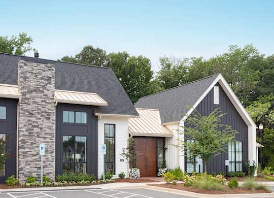 A modern house with a stone pillar in front.