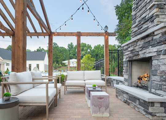 A patio with a fireplace and white furniture.