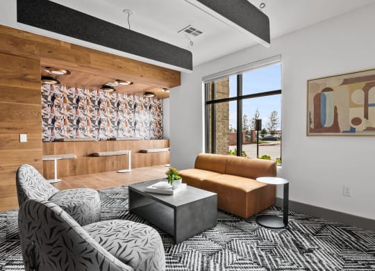 a living room with a brown couch and a black and white rug