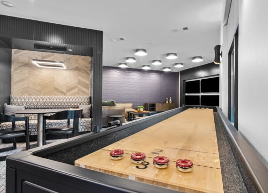 a long wooden ping pong table in a room with a large mirror