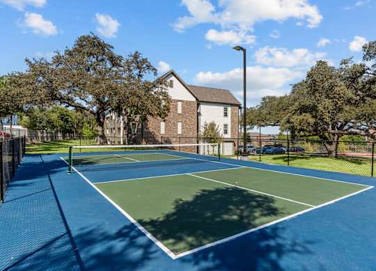 A tennis court with a blue surface and white boundary lines.