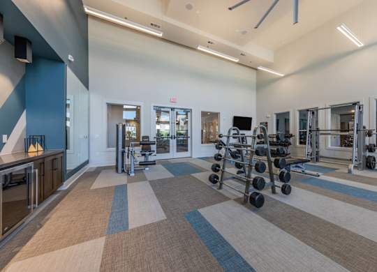 A gym with a variety of equipment including weights and treadmills.
