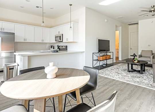 A modern kitchen with a dining table and chairs.
