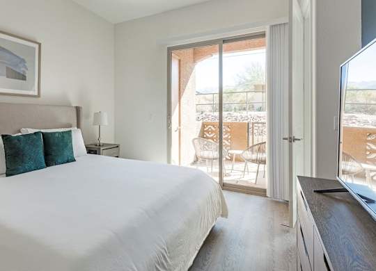 A bedroom with a large bed and a painting on the wall.