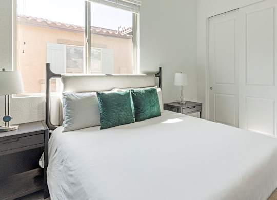 A bedroom with a large bed and a window.