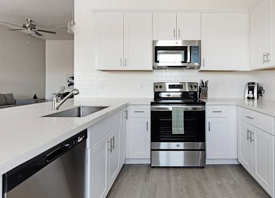 A modern kitchen with white cabinets and stainless steel appliances.