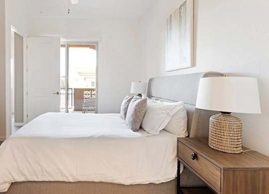 A bedroom with a bed, nightstand, and a television.