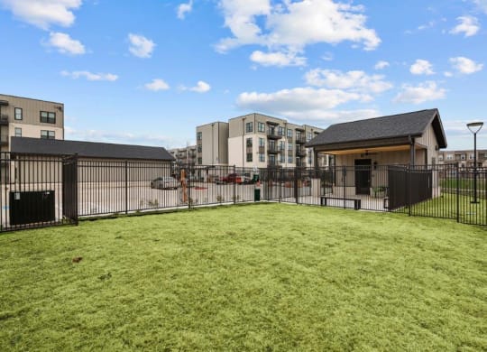 a fenced in yard with apartments in the background
