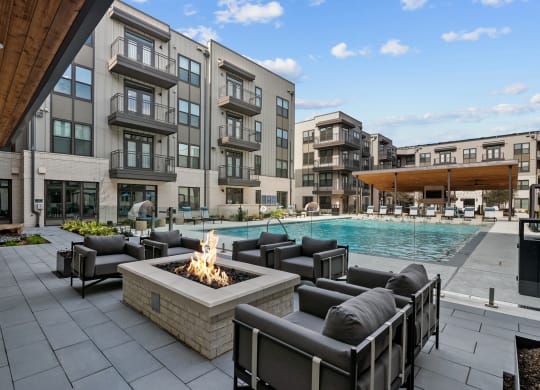 an outdoor patio with chairs and a fire pit and a pool