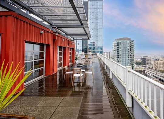 A red building with a glass ceiling and a white railing.