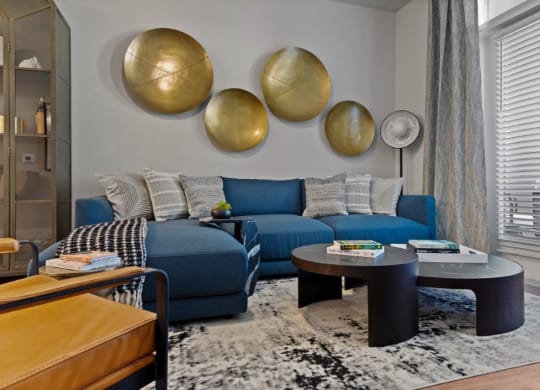 a living room with a blue couch and tables