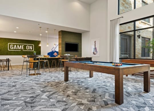 a game room with a pool table and a bar