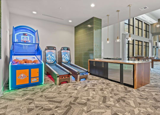 the lobby or reception area of a hotel with game machines and benches