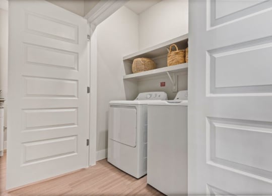 a laundry room with a washer and dryer and a white door