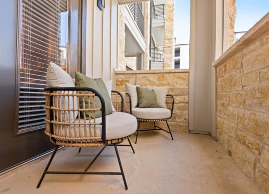 a porch with two chairs and a window