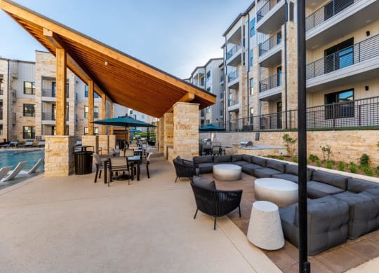 a patio with couches tables and chairs and a pool
