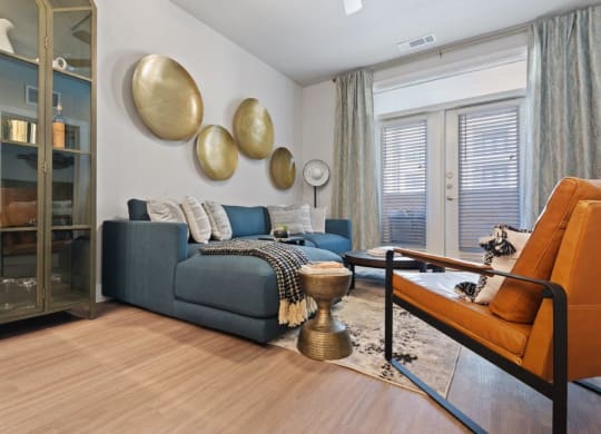 a living room with a couch and a table in front of a window