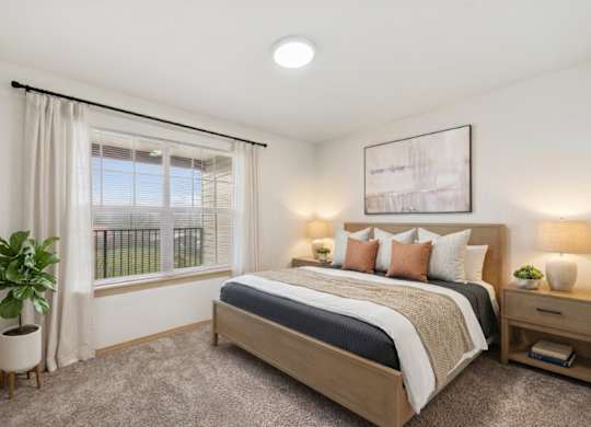 A well-lit bedroom with a large bed and a potted plant.