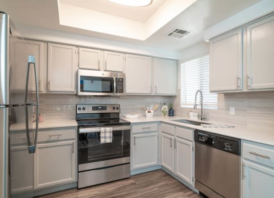 a kitchen with white cabinets and stainless steel appliances