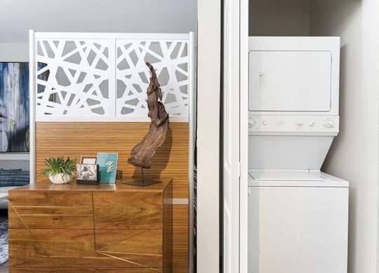 A white oven is in a kitchen next to a wooden dresser.
