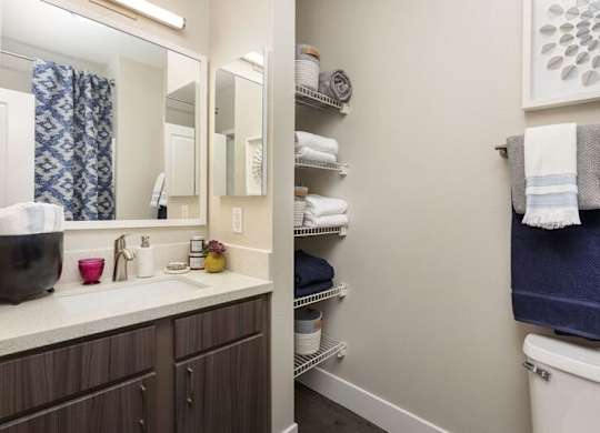 A bathroom with a white sink and a white toilet.