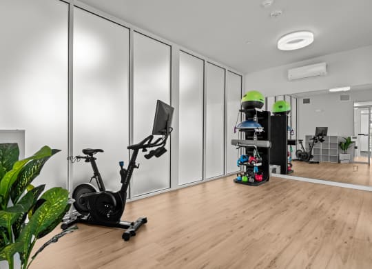 a home gym with white walls and a wood floor