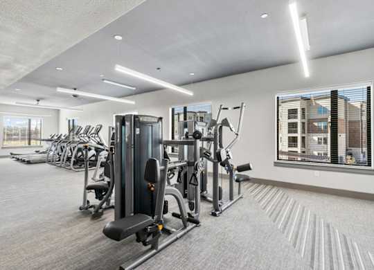 A well-lit gym with a variety of equipment.