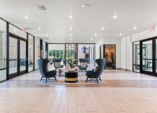 A spacious lobby with wooden floors and modern furniture.