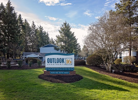 a sign that says outlook 16 with a house and trees in the background