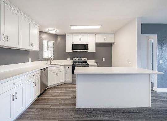 A modern kitchen with white cabinets and a large island.