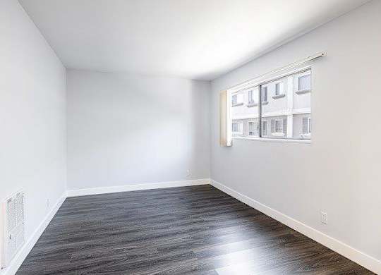 A room with a window and a radiator on the wall.