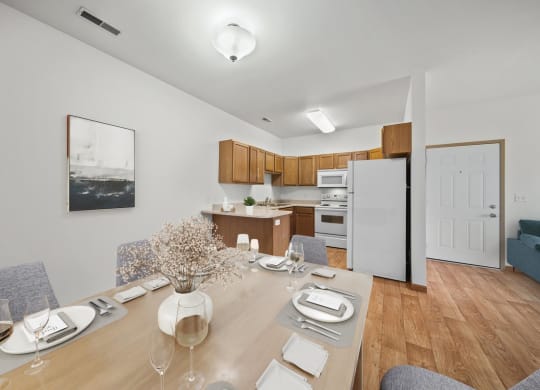 a dining area with a wooden table and chairs and a kitchen in the background